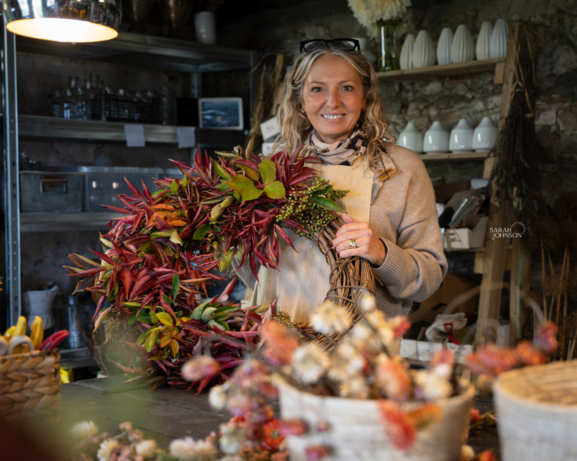 Creative business owner holding a seasonal wreath during a personal branding shoot